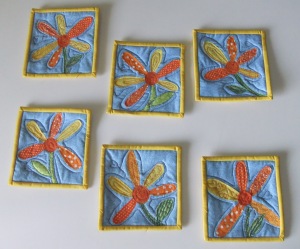 These are 5 and a half inch coasters, with 2 layers of cotton batting. Each one is different- right down to the stitching on the petals.